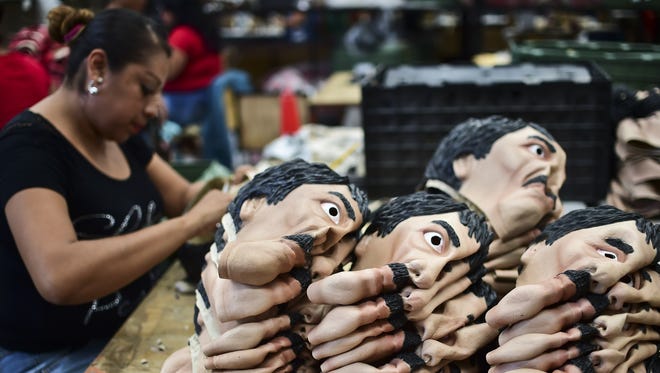 Una mujer acomoda las máscaras con la cara de "El Chapo" Guzmán.