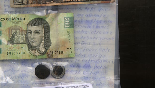 Un billete de 20 dólares, un billete de 200 pesos mexicanos, dos monedas mexicanas (1.50 pesos) y una credencial de elector de México.