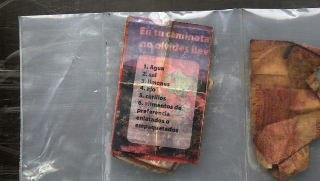 Una cartita que indica al inmigrante una lista de qué llevar durante la caminata en el desierto, y un billete de 100 pesos mexicanos.
