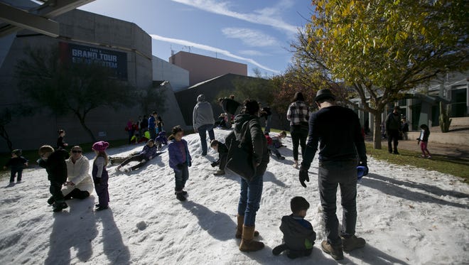 Families play in the snow at the Arizona Science Center in Phoenix on Dec. 26 2016.