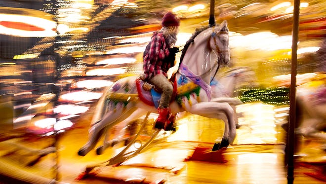 Un ni ñ o monta un caballo en un carrusel en el mercado navide ñ o de Frankfurt, Alemania, el lunes 17 de diciembre de 2018.