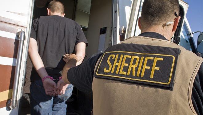Un agente de la Oficina del Alguacil del Condado Maricopa detiene a una persona.