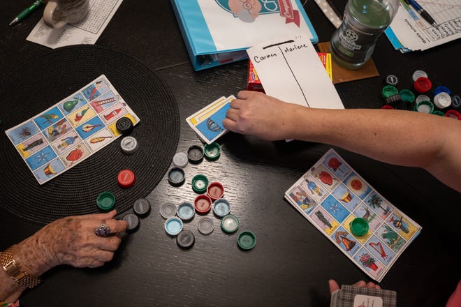 Along with providing care, Carrasco plays games with and helps entertain Carmen Garcia in her Phoenix apartment.