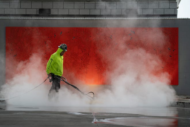 Izzy Amaya steam cleans the pavement at the Thelda Williams Transit Center on Jan. 23, 2024, in Phoenix.