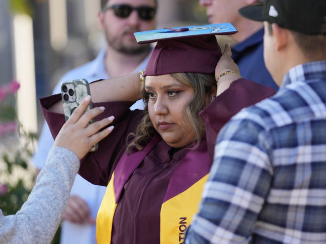 Kimberly Flores puts her cap on before Arizona State University's commencement ceremony in Tempe, Ariz., on May 6, 2024. She is graduating with a degree in psychology.