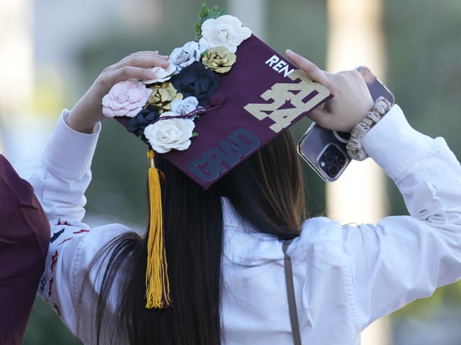 A graduate fixes her cap before Arizona State University's commencement ceremony in Tempe, Ariz., on May 6, 2024.