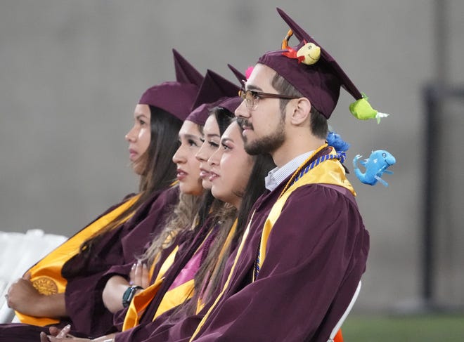 Students watch a video message during Arizona State University's commencement ceremony in Tempe.
