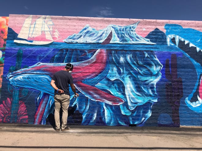 Isaac Caruso pinta su secci ó n de un mural detr á s de The Churchill, cerca de las Calles Primera y McKinley, el s á bado 11 de mayo del 2019.