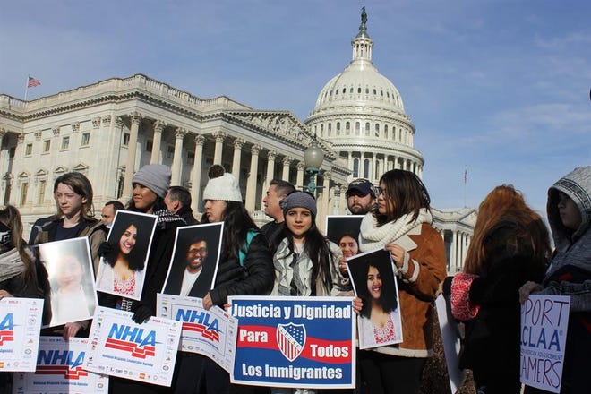 Varios jóvenes sostienen pancartas que reivindican "Justicia y dignidad para todos los inmigrantes".