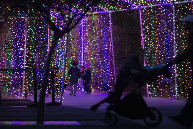Children walk through the entrance for ZooLights on Tuesday, Nov. 26, 2019, at the Phoenix Zoo in Phoenix.