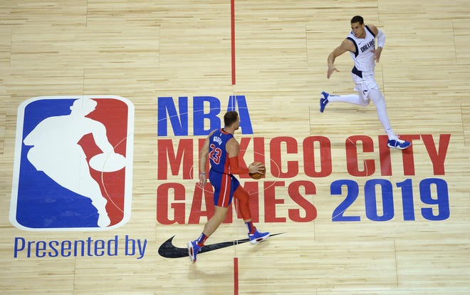 Detroit Pistons forward Blake Griffin dribbles while defended by Dallas Mavericks forward Dwight Powell in the first half in Mexico City, Dec. 12, 2019.