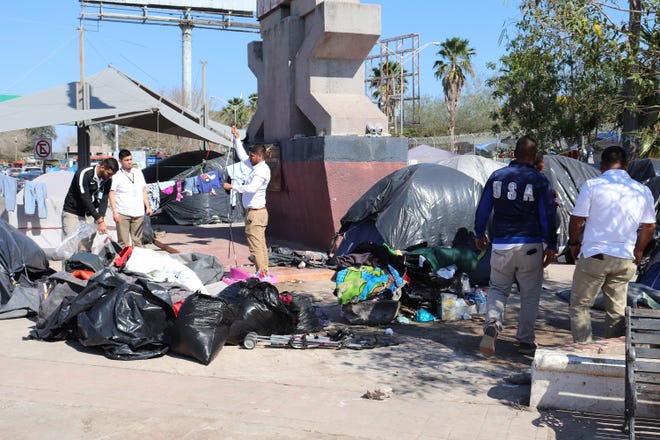 Grupos de personas, pertenecientes a la llamada caravana migrante, esperan para resolver su situación migratoria ayer jueves, en Matamoros, estado de Tamaulipas (México).