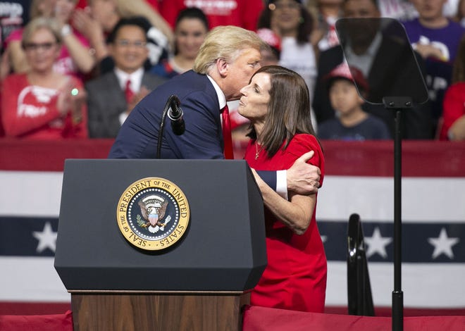 El presidente Donald Trump saluda de beso a la senadora por Arizona Martha McSally.