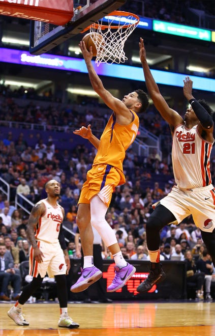 Phoenix Suns guard Devin Booker (1) drives to the basket past Portland Trail Blazers center Hassan Whiteside (21) in the first half at Talking Stick Resort Arena on Mar. 6, 2020 in Phoenix, Ariz.