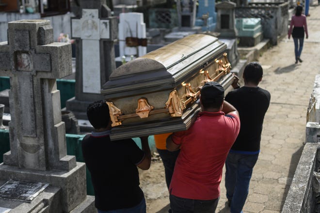 Cuatro hombres cargan sobre su hombro a su familiar fallecido, en un cementerio en Coatzacoalcos, Veracruz, México. Foto archivo.