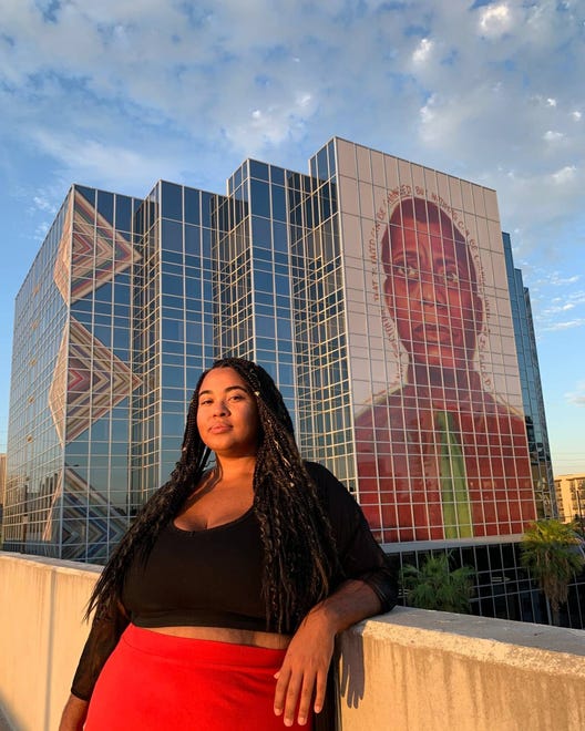 Antoinette Cauley se para frente a su mural de James Baldwin en el edificio Ten-O-One, en la Avenida Central y la Roosevelt, en el Distrito de las Artes de Roosevelt, en Phoenix.