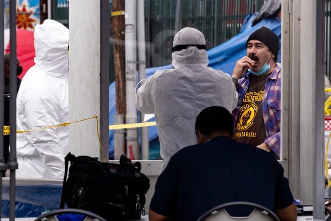 Un hombre toma una muestra en su boca usando un hisopo en un sitio de prueba emergente COVID-19 para personas sin hogar en medio de la pandemia de coronavirus en Skid Row, Los Ángeles, California, EE. UU., 20 de abril de 2020.