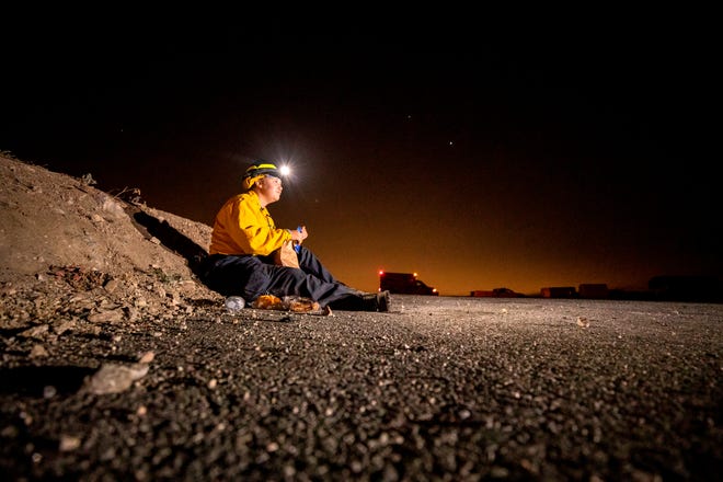 Un bombero se toma un descanso para cenar de sus labores de extinción del incendio Bobcat que continúa arrasando California, cerca de Crystal Lake en Angeles National Forest, Azusa.