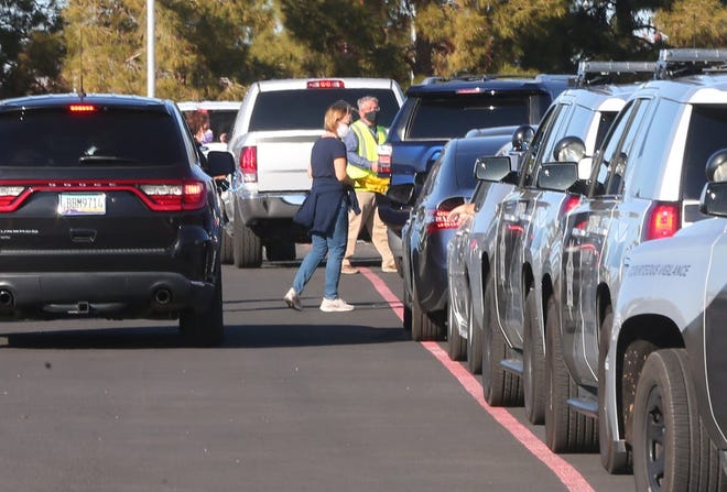 Los autos se alinean durante una prueba de funcionamiento del primer sitio de vacunación COVID-19 24/7 del estado el 11 de enero en el State Farm Stadium en Glendale, Arizona.