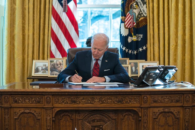 El presidente Joe Biden firma una orden ejecutiva en materia migratoria, en la Oficina Oval de la Casa Blanca, el martes 2 de febrero de 2021, en Washington.