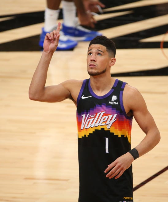 Phoenix Suns guard Devin Booker (1) points before taking the court against the Orlando Magic Feb. 14, 2021.