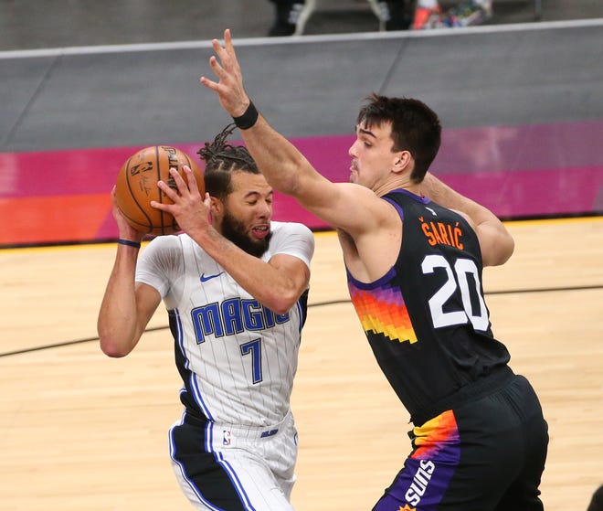 Orlando Magic guard Michael Carter-Williams (7) is defended by Phoenix Suns forward Dario Saric (20) during the first quarter Feb. 14, 2021.