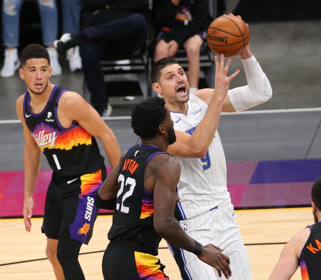 Orlando Magic center Nikola Vucevic (9) is defended by Phoenix Suns center Deandre Ayton (22) during the second quarter Feb. 14, 2021.
