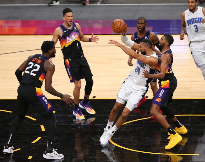 Phoenix Suns forward Mikal Bridges (25) defends against Orlando Magic center Khem Birch (24) during the second quarter Feb. 14, 2021.