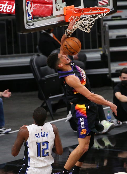 Phoenix Suns guard Devin Booker (1) slams two against Orlando Magic forward Gary Clark (12) during the first quarter Feb. 14, 2021.