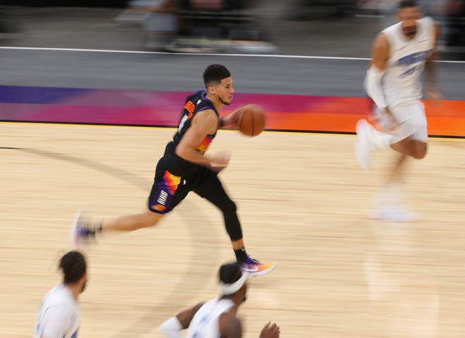 Phoenix Suns guard Devin Booker (1) brings the ball up against the Orlando Magic during the third quarter Feb. 14, 2021.