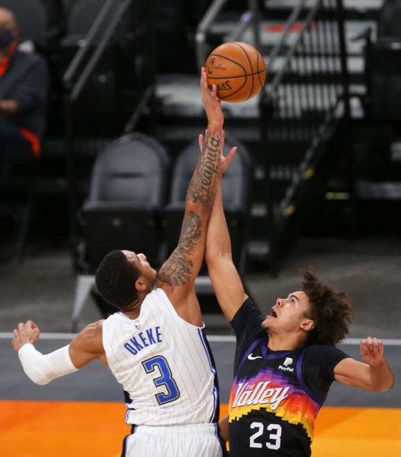 Phoenix Suns forward Cameron Johnson (23) jumps ball with Orlando Magic forward Chuma Okeke (3) during the first quarter Feb. 14, 2021.