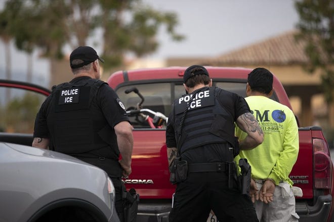Agentes del Servicio de Control de Inmigración y Aduanas de Estados Unidos (ICE por sus siglas en inglés), detienen a un hombre durante un operativo en Escondido, California.